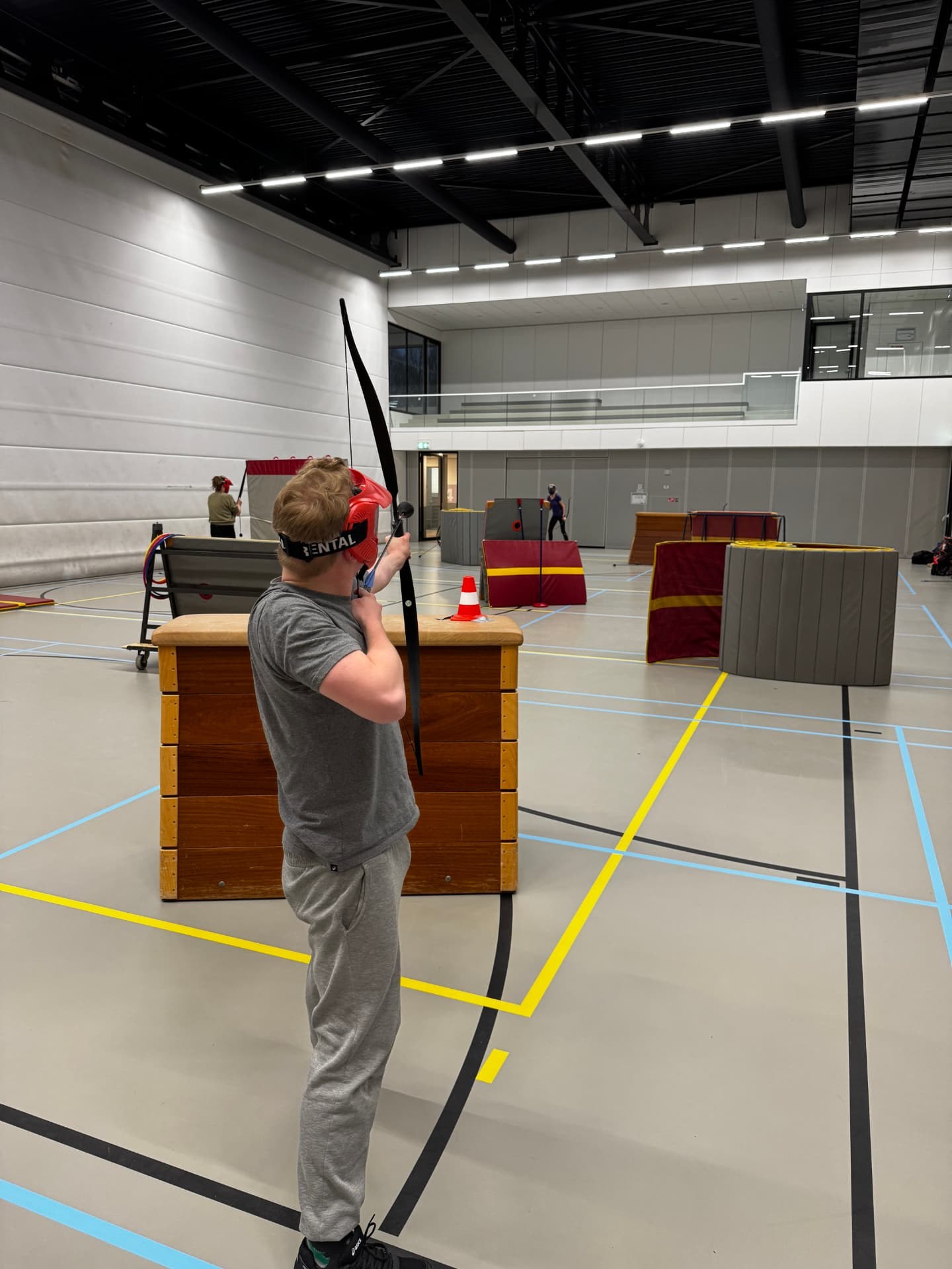 Speler met boog en beschermend masker in de sporthal – verhuur door Uitjes2go in Ede