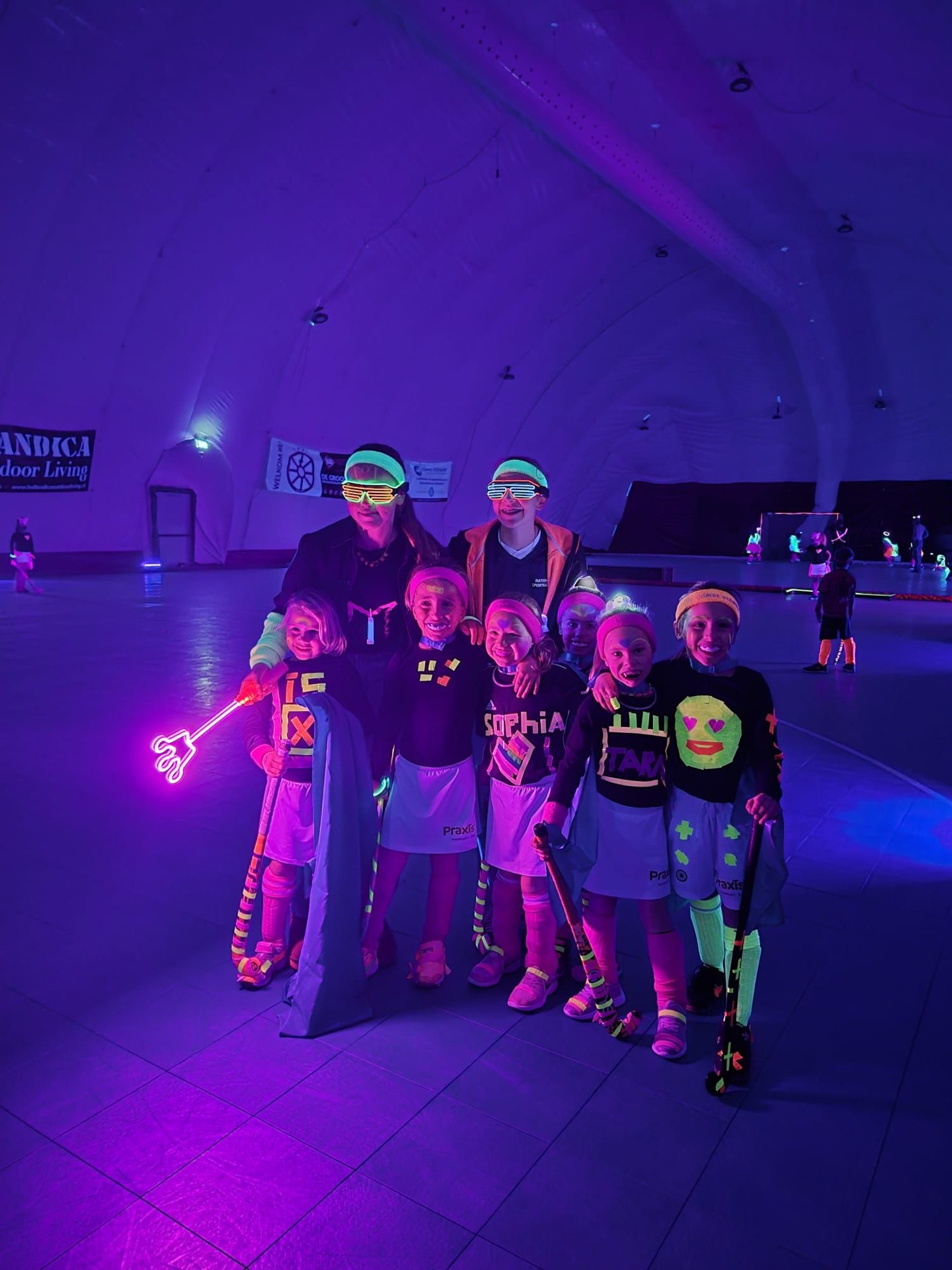 Glow-in-the-dark hockeyteam met neonlinten en sticks onder blacklight – verhuur door Uitjes2go in Ede