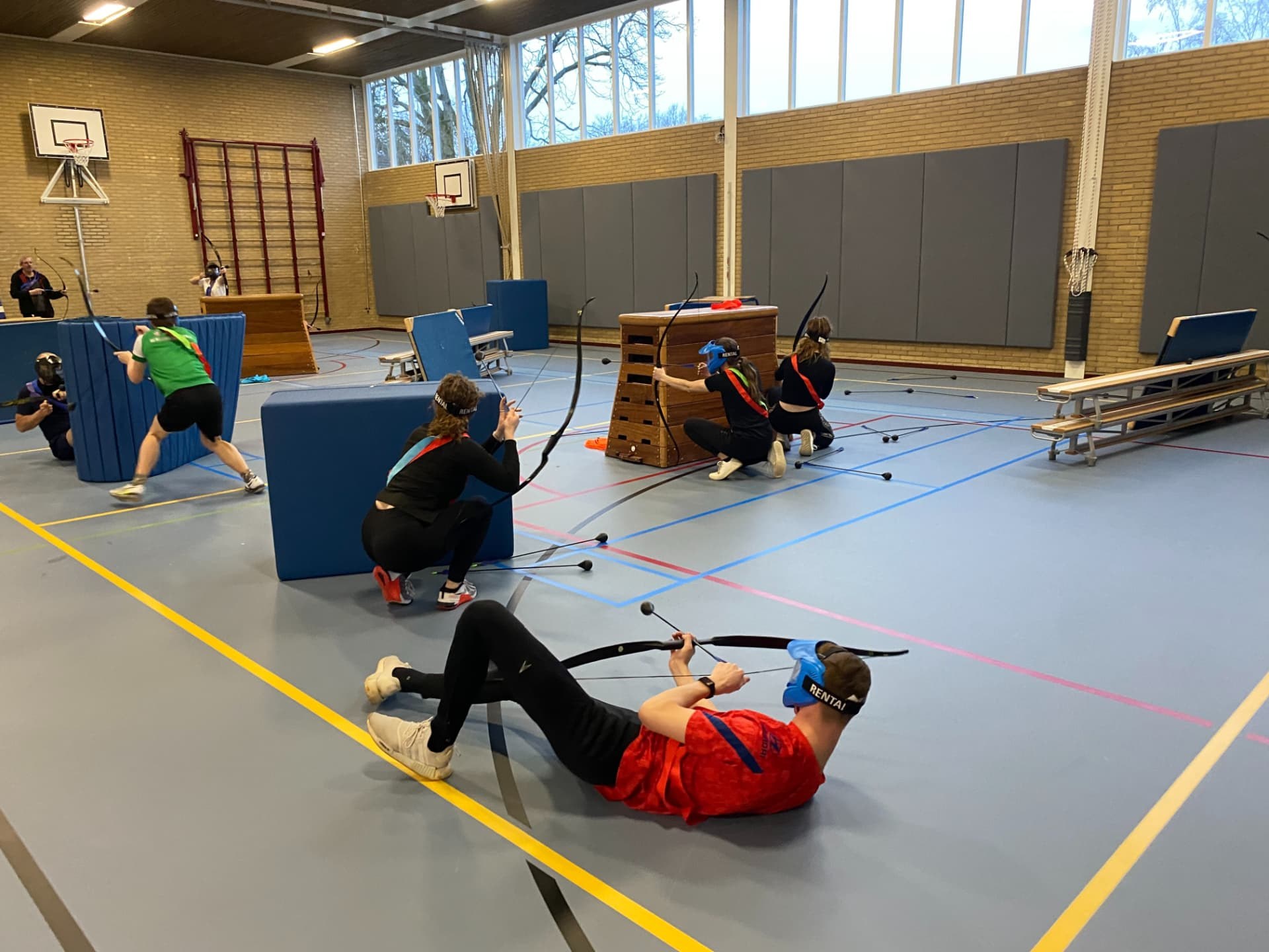 Groep speelt Archery Tag in een sporthal – verhuur door Uitjes2go in Ede